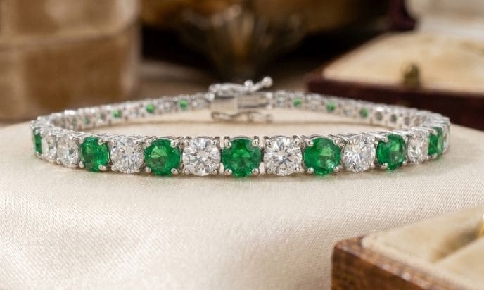 Alternating green emerald and natural diamond tennis bracelet in white gold setting