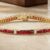 Yellow gold channel-set ruby and diamond tennis bracelet with princess-cut rubies