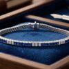 White gold channel-set sapphire and diamond tennis bracelet displayed in luxury blue jewelry box