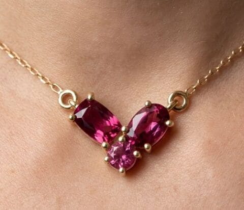 Garnet gold pendant necklace with three-stone design