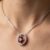 Oval ruby diamond halo pendant necklace in white gold