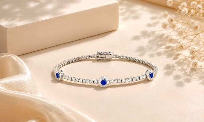 White gold sapphire and diamond tennis bracelet featuring centered floral cluster accents