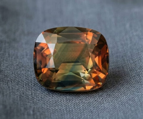 Natural bi-color sapphire cushion cut gemstone with green and orange tones