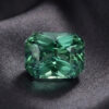 Natural blue green sapphire gemstone on dark grey fabric