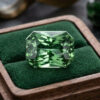 Natural blue green sapphire gemstone on green jewelry display