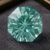 Natural octagonal blue green tourmaline gemstone on dark jewelry display