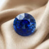 Natural blue sapphire round cut loose gemstone on fabric background