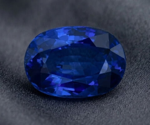 Natural blue sapphire gemstone with GIA report showing oval cut and vivid blue brilliance
