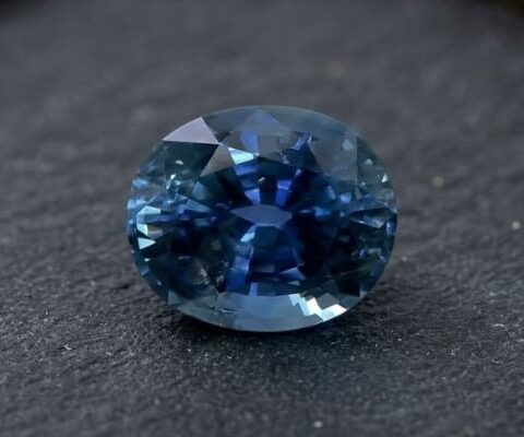 Natural blue sapphire gemstone with oval cut showing deep blue color and brilliant facets