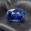 Natural blue sapphire gemstone on dark grey fabric