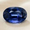 Natural oval blue sapphire gemstone on soft beige fabric