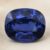 Natural cushion cut blue sapphire gemstone on soft beige fabric