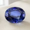 Natural oval blue sapphire with GIA report on soft cream fabric