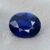 Natural oval blue sapphire with GIA report on soft grey fabric