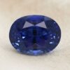 Natural oval blue sapphire gemstone on soft cream fabric