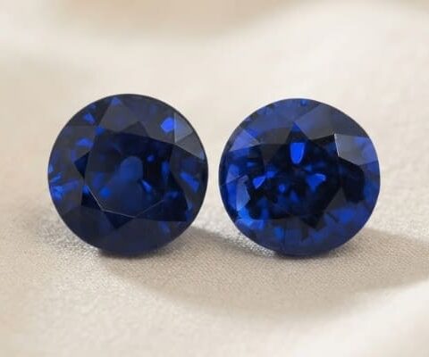Natural round blue sapphire matching pair on soft cream fabric