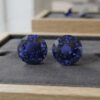 Natural round blue sapphire matching pair on dark grey jewelry tray