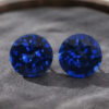 Natural round blue sapphire matching pair on dark grey jewelry display