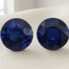Natural round blue sapphire gemstone pair on soft cream fabric