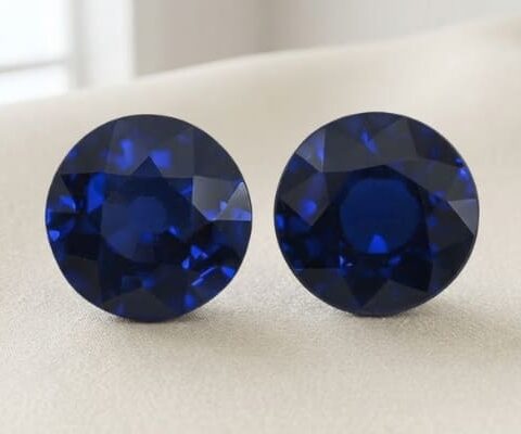 Natural round blue sapphire gemstone pair on soft cream fabric