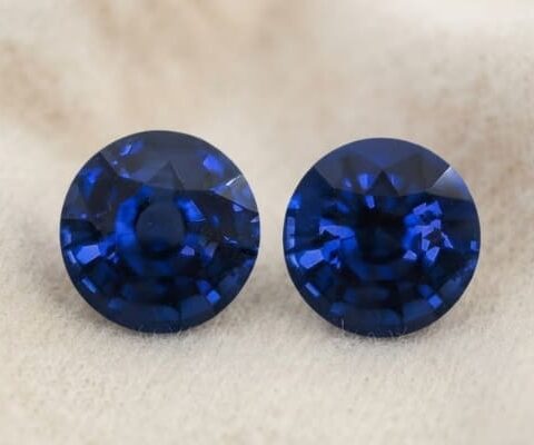 Natural round blue sapphire matching pair on soft beige fabric