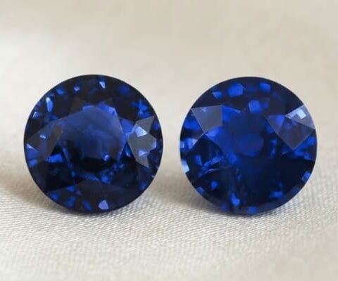 Natural round blue sapphire matching pair on soft cream fabric
