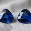 Natural blue sapphire pair with GIA reports on soft grey fabric