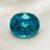 Natural round blue zircon gemstone on soft cream fabric