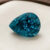 Natural pear shaped blue zircon gemstone on cream jewelry display