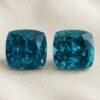 Natural cushion cut blue zircon matching pair on soft cream fabric
