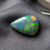 Natural Brazilian opal gemstone on dark grey fabric