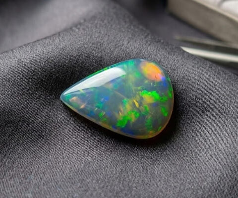 Natural Brazilian opal gemstone on dark grey fabric