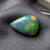 Natural Brazilian opal gemstone on dark grey fabric