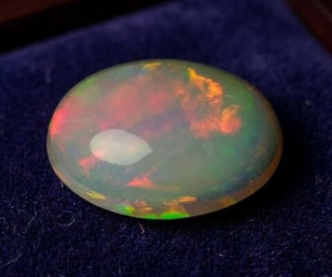 Natural Brazilian opal gemstone on deep blue velvet display