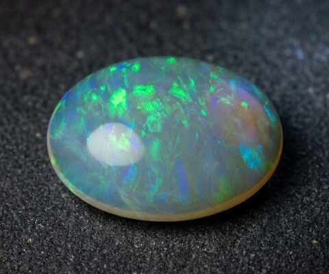 Natural Brazilian opal gemstone on dark stone surface