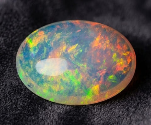 Natural Brazilian opal gemstone on dark velvet fabric