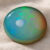 Natural round Brazilian opal gemstone on soft beige fabric