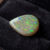 Natural pear shaped Brazilian opal gemstone on black velvet jewelry display