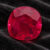 Natural oval Burma ruby with GIA report on black velvet fabric