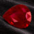 Natural pear shaped Burma ruby gemstone on black textured fabric