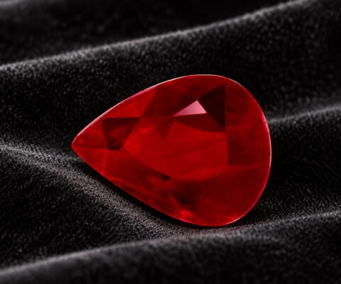 Natural pear shaped Burma ruby gemstone on black velvet fabric