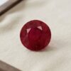 Natural round Burma ruby with GIA report on cream jewelry display