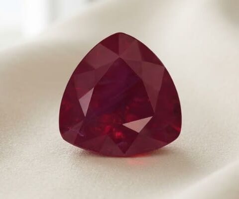 Natural pear shaped Burma ruby with GIA report on soft cream fabric