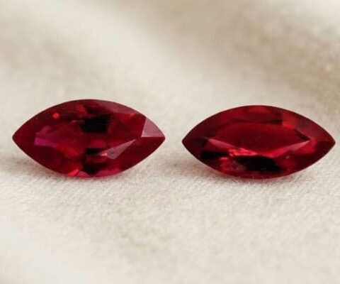 Natural marquise cut Burma ruby matching pair on soft cream fabric