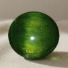 Natural cat’s eye demantoid garnet with GIA report on soft beige fabric