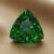 Natural trillion cut chrome tourmaline gemstone on soft beige fabric
