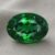 Natural oval chrome tourmaline gemstone on soft grey fabric