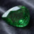 Natural chrome tourmaline gemstone on dark grey fabric