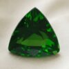 Natural trillion cut chrome tourmaline gemstone on soft cream fabric