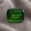 Natural cushion cut chrome tourmaline gemstone on soft grey fabric